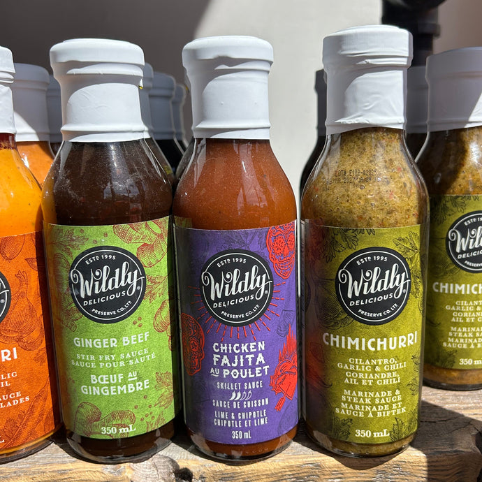 Assorted bottles of Wildly's Sauces on a wooden surface