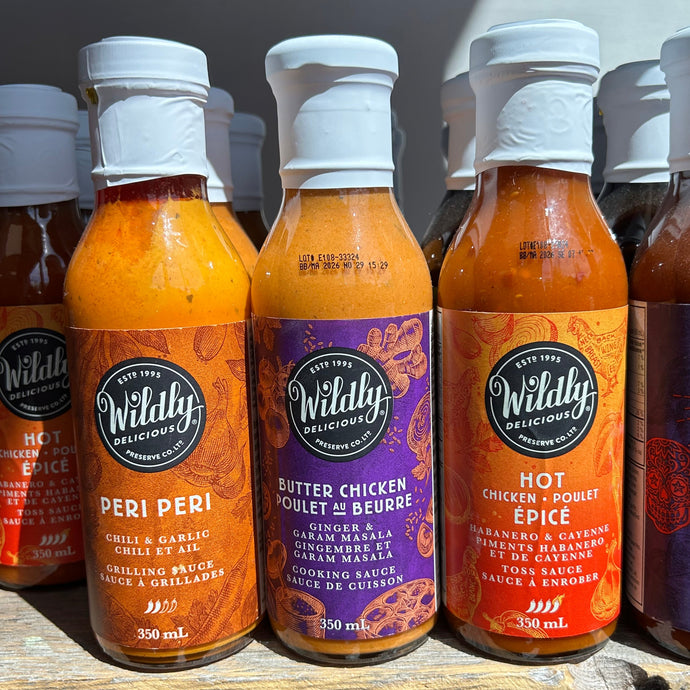 Row of Wildily delicious sauce bottles on a wooden surface