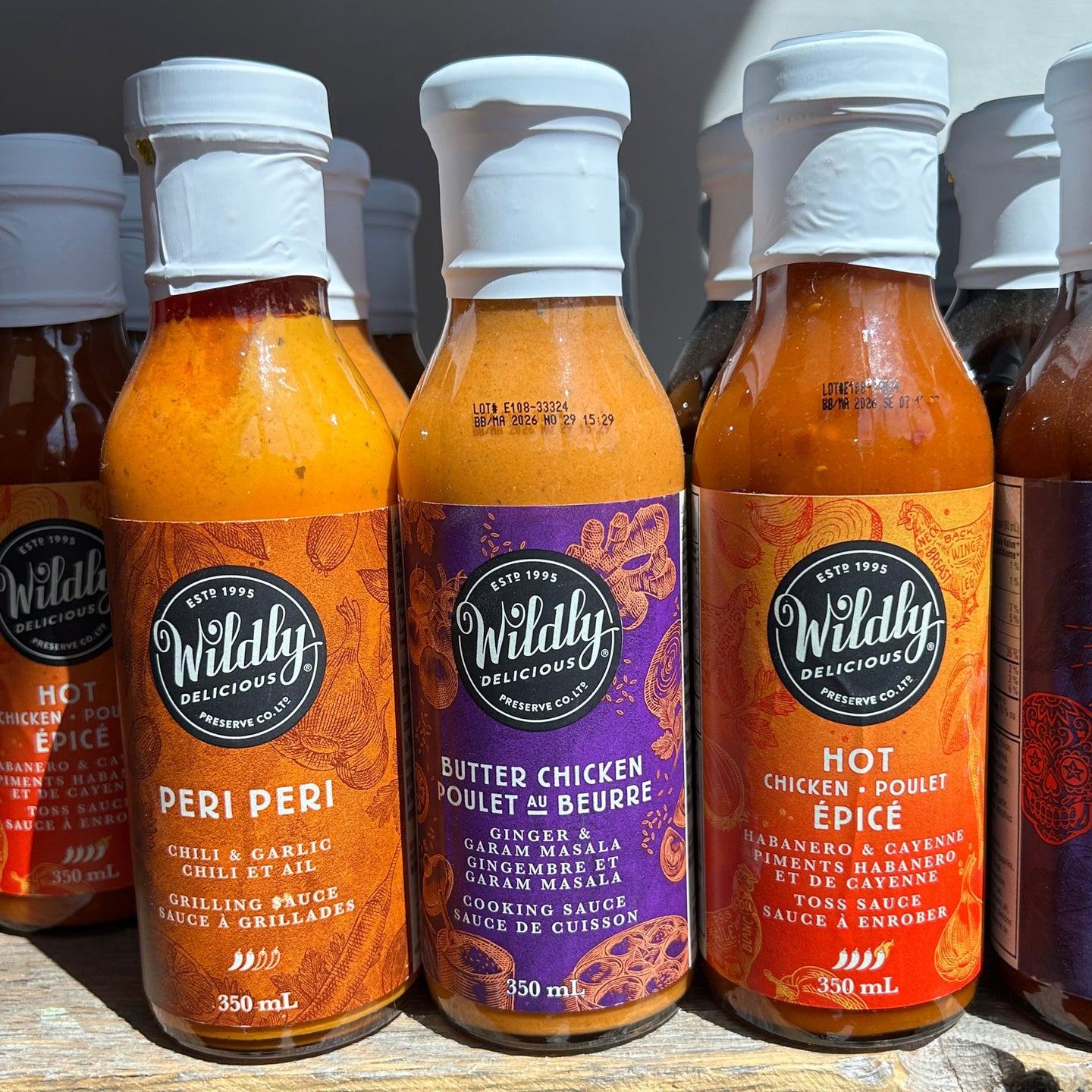 Row of Wildily delicious sauce bottles on a wooden surface